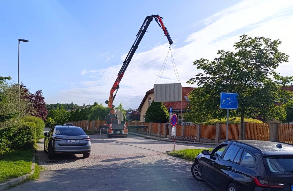 V areálu 1. MŠ proběhla v pondělí 15. června instalace dvou retenčních nádrží na dešťovou vodu. Před instalací nádrží proběhly stavební přípravy včetně vyhloubení jámy a úpravy prostoru. Za pomoci jeřábu a těžké techniky byly do připraveného prostoru uloženy dvě retenční nádrže – typová o objemu 20 m³ a atypická o objemu 10 m³. V následujících dnech budou pokračovat dokončovací práce, zejména betonáže, napojení přípojek a úpravy povrchů. Pokud bude realizace pokračovat podle plánu, zařízení bude na konci června připraveno k plnému provozu. Retenční nádrže jsou součástí systému modrozelené infrastruktury, který podporuje efektivní hospodaření s dešťovou vodou. Zachycená voda bude využívána především k zavlažování zeleně. Menší nádrž poslouží pro potřeby zahrady mateřské školy, větší nádrž pomůže s péčí o veřejnou zeleň v Újezdě nad Lesy. Projekt představuje další krok k modernizaci školního prostředí a odpovědnému přístupu k využívání přírodních zdrojů. Zároveň přispívá k tomu, aby děti již od útlého věku vnímaly význam udržitelného hospodaření s vodou.