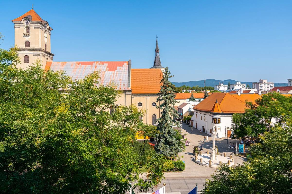 Mesto Pezinok pripravuje počas letných mesiacov dočasnú zmenu využitia priestoru pred Mestským úradom na Radničnom námestí. Miesto, ktoré dnes mnohí vnímajú najmä ako parkovisko, sa počas leta zmení na verejný mestský priestor určený na oddych, stretávanie, pohyb a spoločné trávenie času.🌳 Z tohto dôvodu bude parkovisko pred Mestským úradom na Radničnom námestí dočasne uzatvorené od 18. júna do 3. septembra 2026. Jeden parkovací pás popri ceste zostane počas tohto obdobia zachovaný pre motoristov. 🛝Letný režim bude na Radničnom námestí fungovať počas školských prázdnin, od 1. júla do 31. augusta 2026. Pred jeho spustením bude priestor postupne pripravovaný tak, aby mohol počas leta slúžiť verejnosti bezpečne, funkčne a príjemne. Po skončení letného režimu bude nasledovať uvoľnenie priestoru a opätovné sprístupnenie parkoviska. Počas leta tu obyvatelia a návštevníci nájdu priestor na oddych, posedenie, občerstvenie aj príjemné trávenie času v centre mesta. Súčasťou letnej úpravy priestoru budú prvky na sedenie, tieň a osvieženie počas horúcich dní, zeleň, detské prvky, stánky s občerstvením a priestor na pohybové aktivity. Pre deti a mladých pribudne aj pumptrack, ktorý ponúkne možnosť aktívneho trávenia času priamo v centre Pezinka. 🚴 Cieľom mesta je ukázať, že aj priestor pred radnicou môže byť viac než len miestom na odstavenie áut. Počas leta sa z neho stane otvorené Radničné námestie — miesto, ktoré bude patriť ľuďom, rodinám s deťmi, mladým, seniorom aj návštevníkom mesta. Tento priestor má priniesť do centra Pezinka viac života, tieňa, oddychu, pohybu a komunitnej atmosféry. Bude príležitosťou zastaviť sa, posedieť si, stretnúť sa s priateľmi, tráviť čas s deťmi alebo si jednoducho užiť centrum mesta inak. Dočasné dopravné obmedzenia sú nevyhnutné na prípravu a bezpečné fungovanie priestoru počas leta. Mesto Pezinok preto prosí obyvateľov, návštevníkov aj motoristov o pochopenie, trpezlivosť a rešpektovanie dočasnej organizácie priestoru. 💚Ďakujeme, že spolu pomáhame vytvárať miesto, ktoré nie je len parkoviskom, ale aj miestom na život.