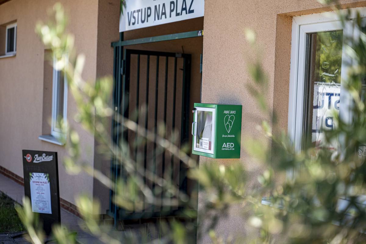 Na verejne dostupnom mieste pri vstupe do Beach Bar Rezort Zelená Voda je od dnešného dňa k dispozícii AED defibrilátor (automatický externý defibrilátor). 📍 Umiestnený je v blízkosti pláže, cyklochodníka 🚴♂️ a frekventovaných oddychových zón tak, aby bol v prípade potreby čo najrýchlejšie dostupný. ❤️ AED je zariadenie určené na poskytnutie prvej pomoci pri náhlom zastavení srdca. Dokáže analyzovať srdcový rytmus a hlasovými pokynmi navádzať zachraňujúcu osobu pri poskytovaní pomoci. Práve prvé minúty po kolapse sú rozhodujúce a včasné použitie AED môže výrazne zvýšiť šancu na záchranu života. ⏱️💓 📞 Defibrilátor na Zelenej vode je zároveň registrovaný v systéme záchrany a evidovaný pre potreby tiesňových liniek 155 a 112. Operátori tak v prípade núdze vedia o jeho presnej polohe a môžu volajúceho navigovať k jeho použitiu ešte pred príchodom záchrannej zdravotnej služby. 🚑 🩹 Súčasťou vybavenia je aj jednorazový záchranný balíček, v ktorom sa nachádzajú pomôcky potrebné pri poskytovaní prvej pomoci vrátane ochranného náustku pre prípad potreby umelého dýchania. 📱 Na skrinke AED nájdete aj QR kód, ktorý vás po načítaní prevedie základnými krokmi poskytovania prvej pomoci a používania defibrilátora. 🔓 Skrinka AED je zabezpečená ochrannou plombou, ktorú je možné v prípade núdze veľmi jednoducho odstrániť. Po otvorení sa zároveň aktivuje výrazný akustický alarm 🔊, ktorý upozorní okolie na mimoriadnu situáciu a môže privolať ďalších ľudí na pomoc. Alarm neslúži na odradenie od použitia zariadenia – práve naopak. V prípade potreby neváhajte AED použiť. 🙌 🙏 Veríme, že AED zostane počas celého leta nevyužitý a bude slúžiť len ako poistka pre prípad núdze. Je však dobré vedieť, že na mieste, kde sa denne pohybujú stovky návštevníkov, plavcov 🏊, športovcov 🏃, cyklistov 🚴 a rodín s deťmi 👨👩👧👦, je pomoc na dosah. ☀️🏖️ Prajeme vám pokojné, príjemné a bezpečné leto pri Zelenej vode. ❤️ A keby predsa len nastala situácia, keď pôjde o sekundy, buďte pripravení. Zachovajte pokoj, privolajte pomoc 📞 a použite AED. Vaša rýchla reakcia môže zachrániť ľudský život. ❤️🚑🫶 #BezpečnáZelenáVoda #AED #PrváPomoc #ZelenáVoda #BezpečnéLeto #NovéMestoNadVáhom #ZachráňŽivot #AEDNaDosah #PomocNaDosah ❤️☀️🏖️🚴♂️🚑🩹📱💓 Nové Mesto nad Váhom- Oficiálne stránky mesta | www.nove-mesto.sk