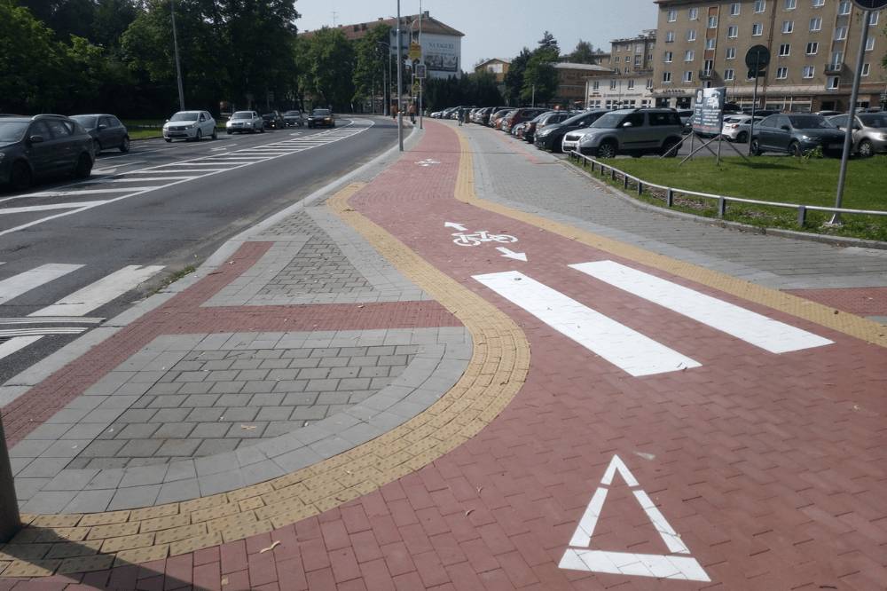 Moravskoslezský kraj byl dlouhá léta spojován především s těžkým průmyslem, uhlím a odchodem mladých lidí. Dnes však ukazuje jinou tvář. Proměna regionu se neodehrává jen prostřednictvím velkých investic a technologických projektů, ale také díky změnám, které lidé využívají každý den. Příkladem je Havířov, kde vznikly nové cyklostezky financované z evropského programu Spravedlivá transformace, který spravuje Ministerstvo životního prostředí. Projekt přispívá k bezpečnější dopravě, kvalitnějšímu veřejnému prostoru a celkově příjemnějšímu životu ve městě. Ještě před několika lety byl pohyb po Havířově bez auta často nepohodlný a místy i nebezpečný. Dnes se situace postupně mění. Na Národní třídě vznikla nová obousměrná cyklostezka s odděleným prostorem pro chodce a cyklisty. Podobná úprava byla realizována také na ulici Československé armády, kde nový úsek zvyšuje bezpečnost v jedné z frekventovaných částí města. Nejde přitom jen o dopravu. Moderní města dnes lidé hodnotí také podle kvality veřejného prostoru, možností trávení volného času a celkové atmosféry. Mladá generace chce žít ve městech, kde lze bezpečně jezdit na kole, pohodlně se pohybovat a trávit čas venku bez nutnosti používat auto na každou cestu. Cyklostezky proto nejsou pouze dopravní stavbou. Propojují školy, služby, parky i jednotlivé části města a pomáhají vytvářet prostředí, které je otevřenější, modernější a přívětivější pro obyvatele všech generací. Havířov tak ukazuje, že skutečná proměna regionů často začíná zdánlivě obyčejnými projekty. Bezpečnější pohyb po městě, kvalitnější veřejný prostor a lepší podmínky pro každodenní život mohou mít na budoucnost města stejně velký dopad jako velké investice. Moravskoslezský kraj dnes stále více dokazuje, že jeho budoucnost nemusí být spojena pouze s průmyslovou minulostí. Díky podpoře z evropských fondů vznikají projekty, které zvyšují kvalitu života a pomáhají vytvářet prostředí, kde chtějí lidé zůstávat, pracovat i vychovávat své rodiny. Zdroj: Operační program spravedlivá transformace Více na opst.cz