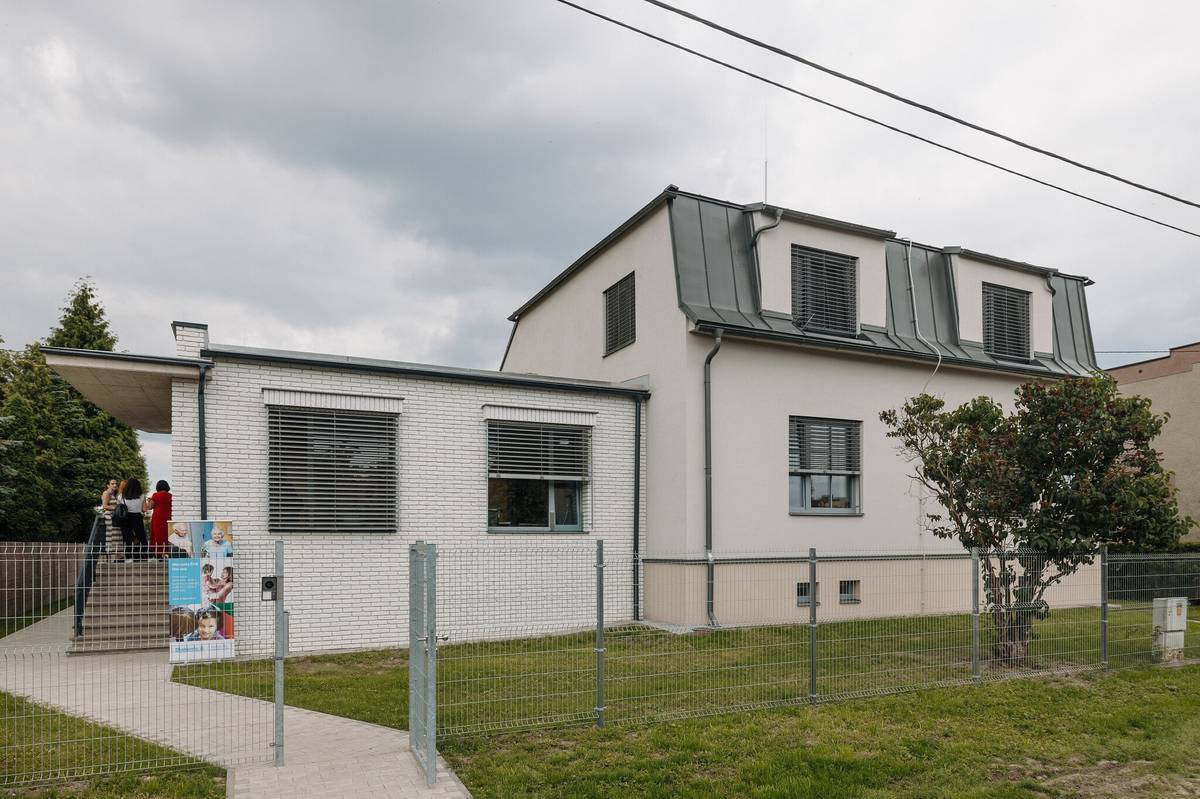 Azylový dům Debora pro ženy a matky s dětmi, který provozuje Diakonie ČCE Ostrava v Ostravě-Zábřehu, slavnostně představil zrekonstruované a rozšířené prostory. Modernizace zařízení zahrnovala novou přístavbu s návštěvní místností, společenským prostorem a zázemím pro sociální pracovníky. Tyto prostory budou sloužit nejen pro individuální konzultace, ale také pro setkávání klientek s jejich blízkými a společné aktivity dětí. Rekonstrukce a přístavba byly součástí projektu financovaného převážně z prostředků Ministerstva práce a sociálních věcí prostřednictvím Národního plánu obnovy. Celkové investiční náklady dosáhly téměř 23 milionů korun, přičemž dotace činila 19,5 milionu korun. Rozvoj zařízení tímto navíc nekončí. Diakonie ČCE Ostrava připravuje další etapu projektu, která se zaměří na úpravu venkovního areálu. V plánu je vybudování dětského hřiště a odpočinkové zóny s prostorem pro hry, setkávání i trávení volného času. Azylový dům Debora poskytuje pomoc ženám a matkám s dětmi, které se ocitly v těžké životní situaci, například v důsledku ztráty bydlení, domácího násilí, zadluženosti nebo komplikovaných rodinných vztahů. Služba funguje od roku 2007 a za dobu svého působení pomohla již 668 ženám a dětem najít bezpečné zázemí a cestu k novému začátku. Více info: https://ostrava.diakonie.cz/sluzba-oj/azylovy-dum-debora-pro-zeny-a-matky-s-detmi/
