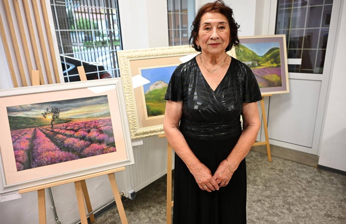 Ester Beláková predstavila vo výstavnej sieni Mestskej knižnice svoju tvorbu pod názvom „Žena, príroda a ich krásy“. Výstava ponúkla návštevníkom pohľad do sveta autorky, ktorá sa vo svojej tvorbe dlhodobo venuje najmä motívom prírody, kvetov a ženskému pôvabu. Rodáčka z Vrútok prejavovala výtvarný talent už od detstva a hoci jej životná cesta smerovala k ekonomickému povolaniu, láska k umeniu ju nikdy neopustila. K intenzívnejšej tvorbe sa vrátila koncom 90. rokov, keď ju povzbudil dar pastelových farieb od priateľky Jindry Holej. Práve tento moment sa stal významným impulzom pre jej ďalšie umelecké smerovanie. Od roku 2002 vytvorila viac ako dvesto obrazov. V posledných rokoch sa venovala aj náročnejším motívom skalnatých horských masívov, ktoré vnímala ako výzvu pre svoje maliarske schopnosti. Ester Beláková svoju prvú samostatnú výstavu uskutočnila práve v Trenčianskych Tepliciach v roku 2005. Nasledovali prezentácie jej tvorby v Trenčíne, Bojniciach, Ilave a ďalšie spoločné výstavy. Významnú podporu na jej umeleckej ceste jej poskytli viacerí ľudia, medzi nimi aj primátorka mesta Zuzana Frajková Ďurmeková, ktorá sa vernisáže zúčastnila. „Žena, príroda a jej krásy je vlastne charakteristika autorky samotnej. Je to žena, ktorá dáva svoje pocity na plátno. Som rada, že možno práve aj mojim pričinením sa posunula dopredu a dnes vidíme svetlé, veselé obrazy, ktoré odzrkadľujú jej dušu,“ povedala primátorka mesta. Príbeh Ester Belákovej je dôkazom, že umelecký talent môže dozrievať aj popri pracovných a rodinných povinnostiach. Jej obrazy sú výsledkom dlhoročnej trpezlivosti, vytrvalosti a úprimného vzťahu ku kráse prírody, ktorá sa stala nevyčerpateľným zdrojom inšpirácie. Výstava „Žena, príroda a ich krásy“ tak predstavuje nielen kolekciu obrazov, ale aj osobný príbeh autorky, ktorá prostredníctvom farieb a tvarov odhaľuje svoj vnútorný svet. Jedinečnú výstavu si môžete vychutnať do 9. júla 2026 v Mestskej knižnici.