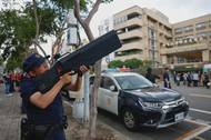 Policisté předvádějí použití systému proti dronům ADS MK6 před nemocnicí během tréninku pro případ čínské invaze nebo katastrofy
