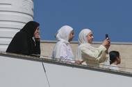Palestinky pozorují ze střechy domu izraelské osadníky přicházející do vesnice Till