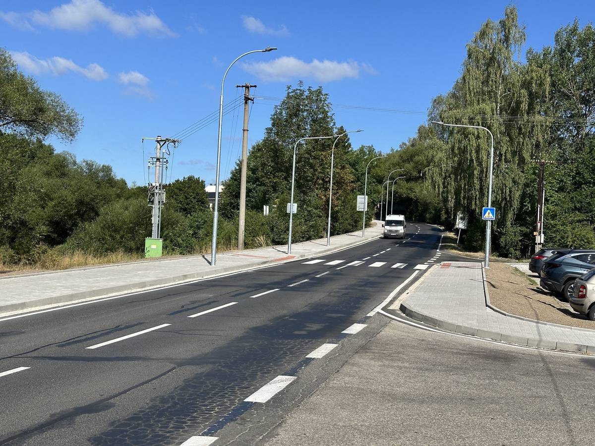 CHODOV (11. 8. 2026) – Město dokončilo nový chodník, který vede od prostoru bývalých sádek za obchodním domem Penny směrem k rodinným domům na okraji Chodova. Trasa dlouhá necelý kilometr výrazně zvýšila bezpečnost chodců v úseku, kde dosud odpovídající pěší spojení chybělo. Součástí úprav byla také změna dopravního značení. Označení začátku Chodova se posunulo blíže k městu a z úseku zmizelo místní omezení rychlosti na 70 kilometrů v hodině. „Příjezd od Vřesové je tak nyní plynulejší, řidiči začínají zpomalovat až blíže k městské zástavbě,“ poznamenal starosta Patrik Pizinger. Náklady na vybudování chodníku dosáhly částky přibližně 5, 2 milionu korun bez DPH. Město se podařilo na stavbu získat dotaci ve výši zhruba čtyř milionů korun. Projekt „Výstavba chodníku včetně osvětlení v Husově ulici“ je spolufinancován Evropskou unií. Parkovací místa jsou v přípravě Město zároveň připravuje další úpravu této lokality. Naproti novému chodníku, v prostoru u bývalé střelnice, by tak mohlo vzniknout přibližně dvacet parkovacích míst. V současné době se zpracovává projektová dokumentace, která určí přesné uspořádání i konečný počet stání. Předpokládané náklady bude možné stanovit až po jejím dokončení.