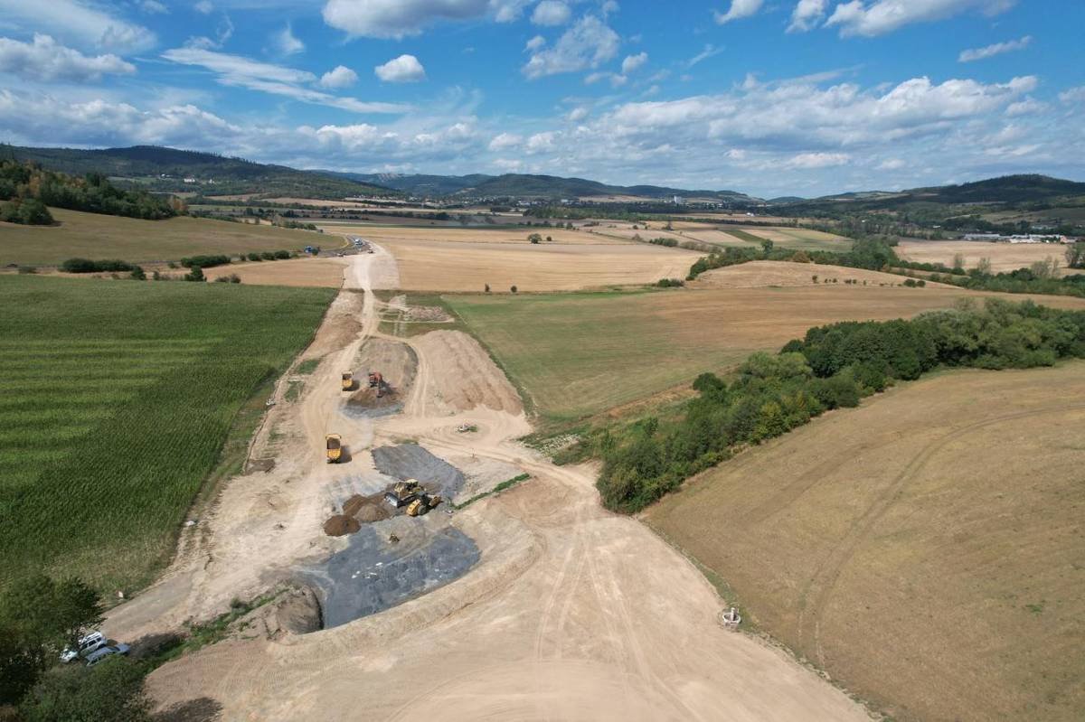 Práce na nové přeložce silnice I/57 u Linhartov pokračují. Zatímco řidiči stále využívají stávající trasu s charakteristickými „linhartovskými zatáčkami“, vedle ní už je v krajině dobře patrný koridor budoucí silnice.